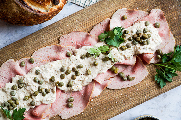 vitello tonnato op een houten plank met boerenbrood